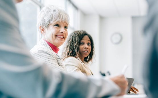 Close Up Of Older Woman Smiling In Meeting