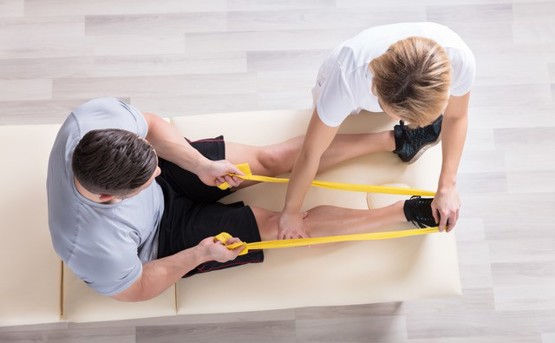 a physio therapist helps a patient stretch their foot