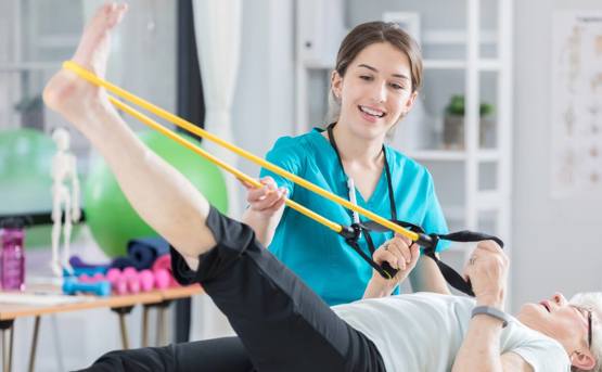 a medical profesional helps a patient stretch their leg 